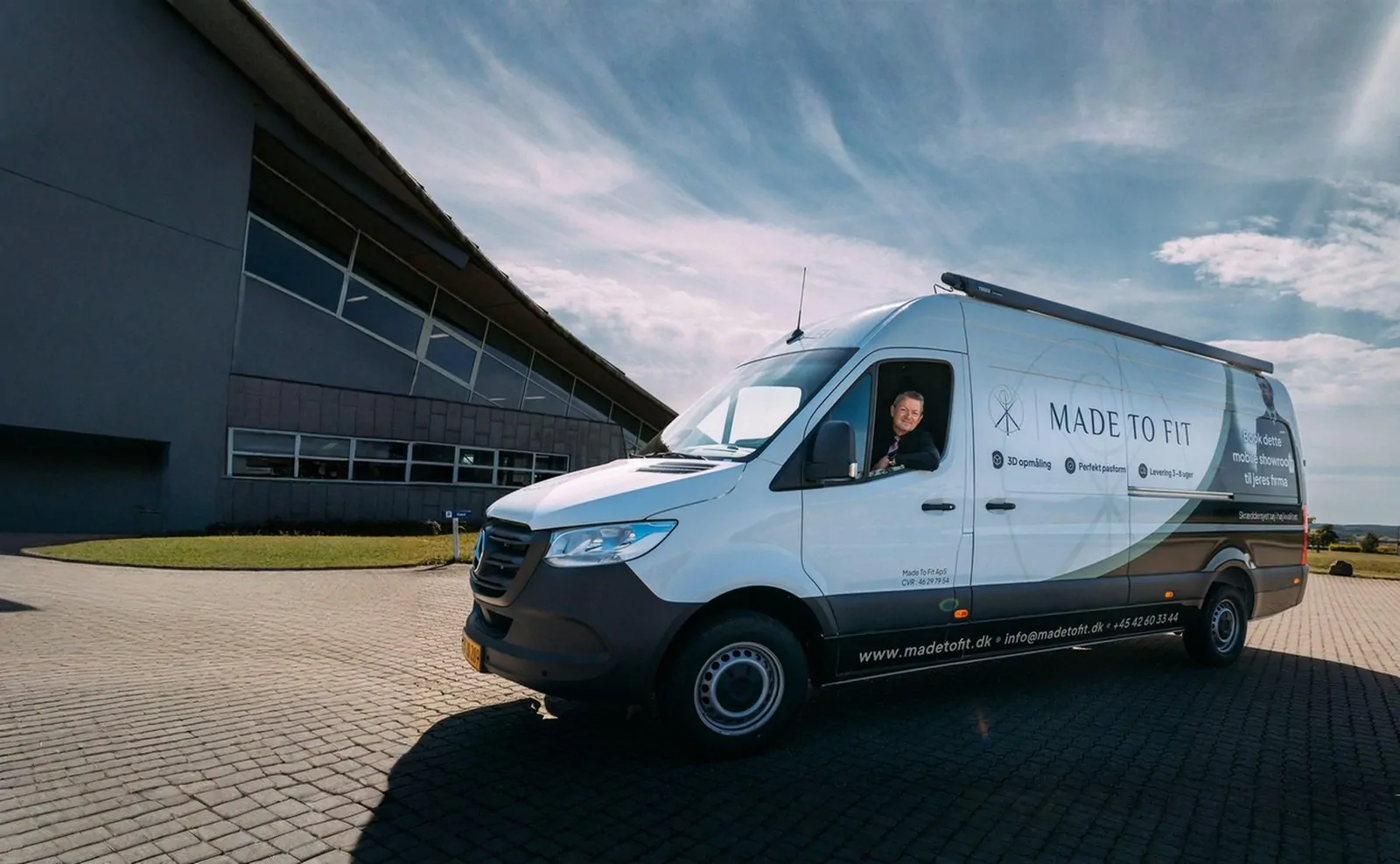 Made To Fit's mobile showroom — en Mercedes Sprinter med firmaets logo, parkeret foran en bygning i Lisbjerg.